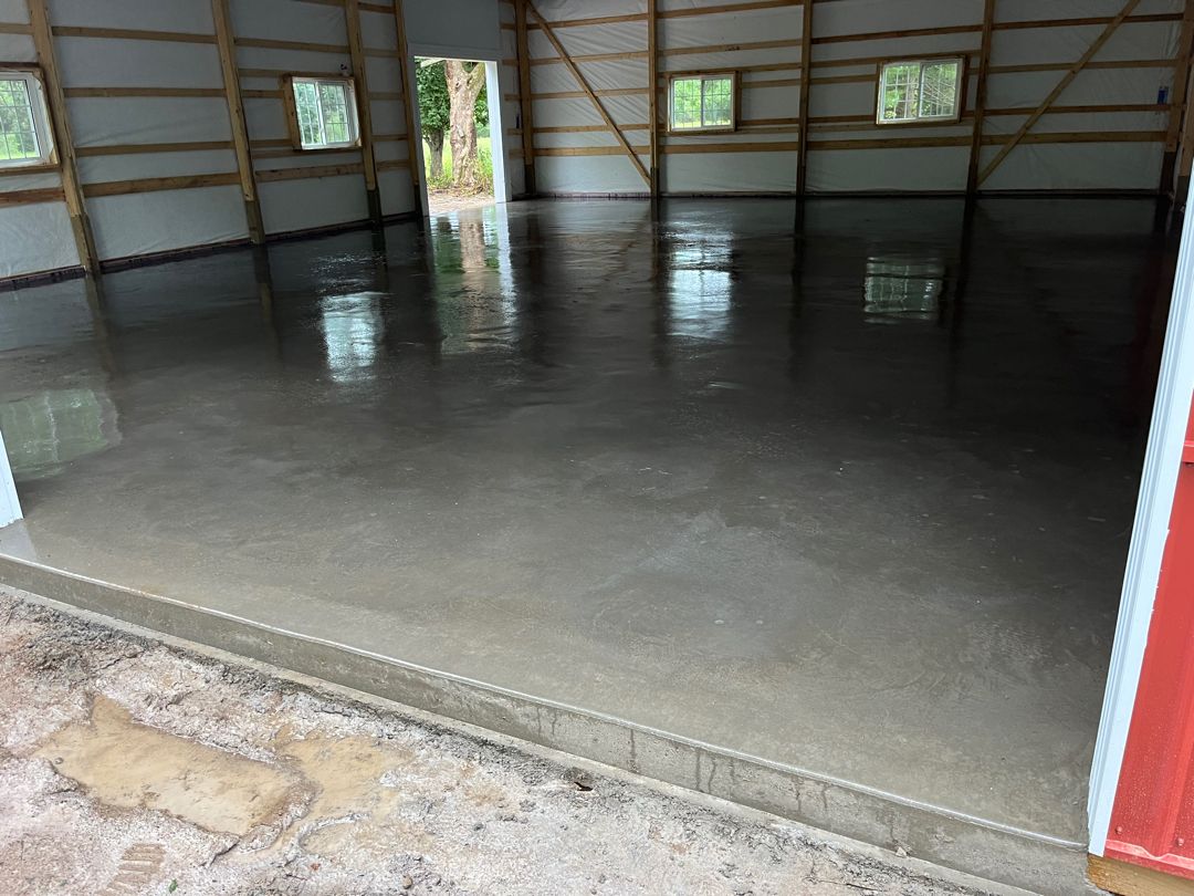 Interior of a large, empty garage with a smooth, freshly poured concrete garage floor in Monticello, MN.